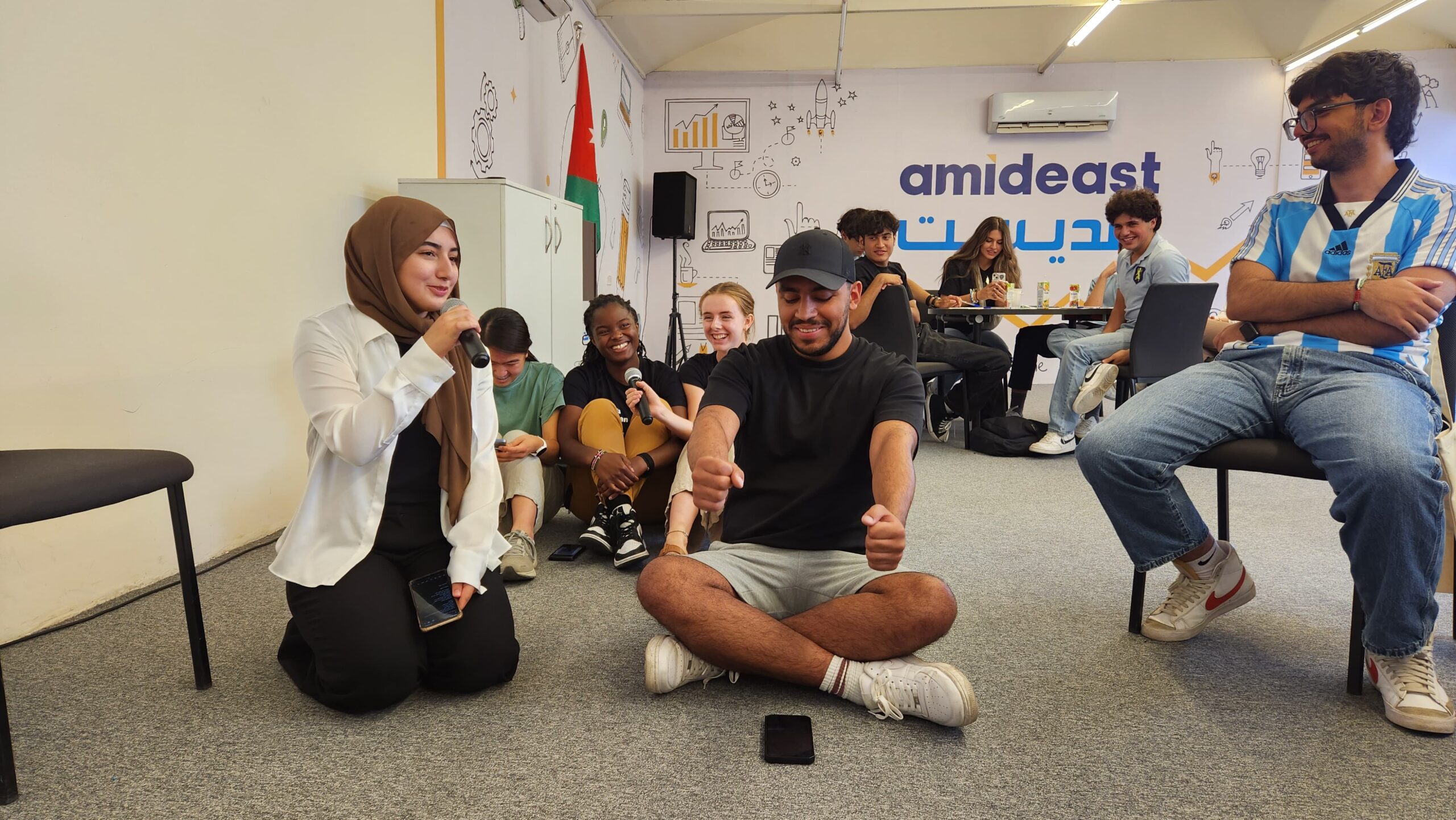 An image of students laughing during a game in an Arabic classroom