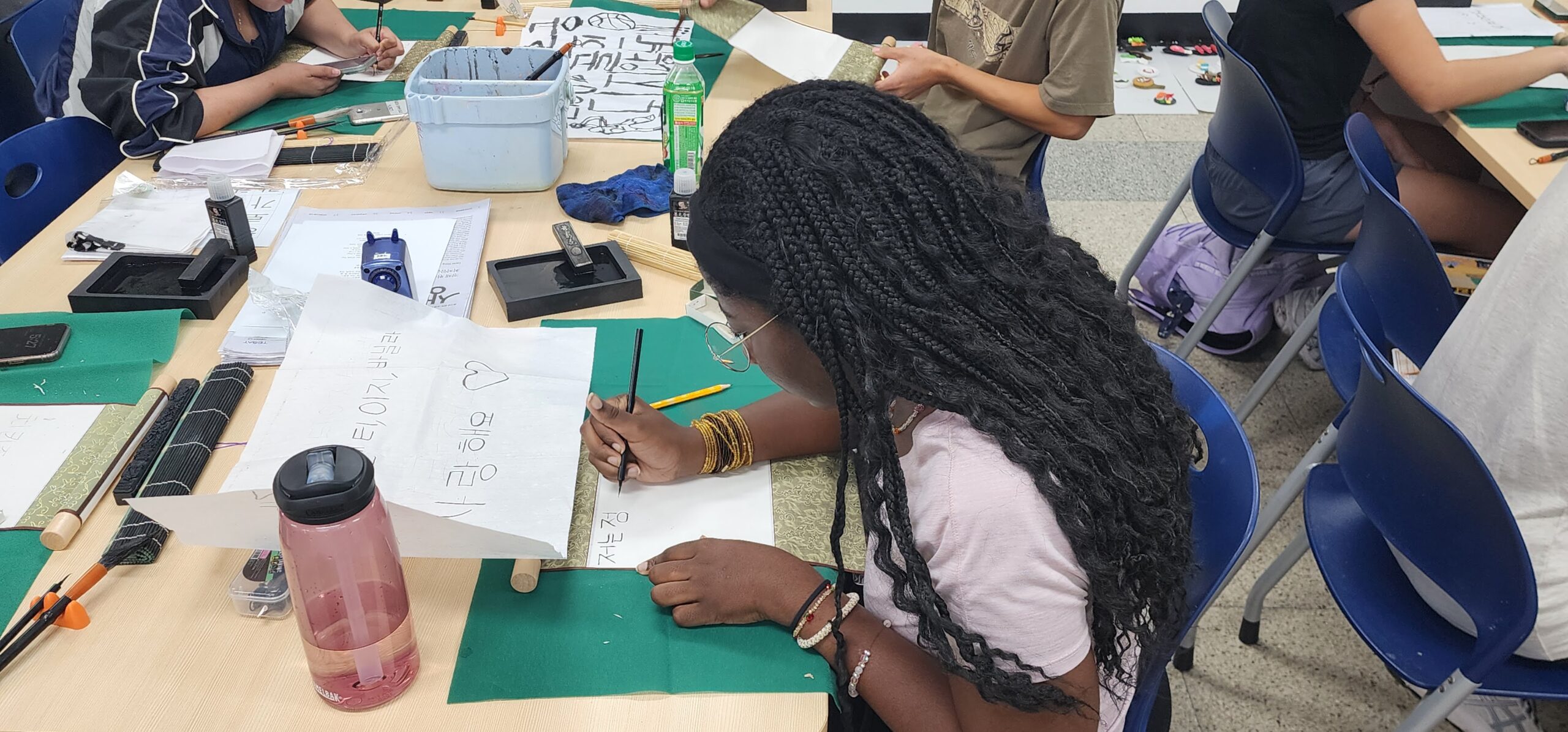 Student practicing Korean hangul on paper