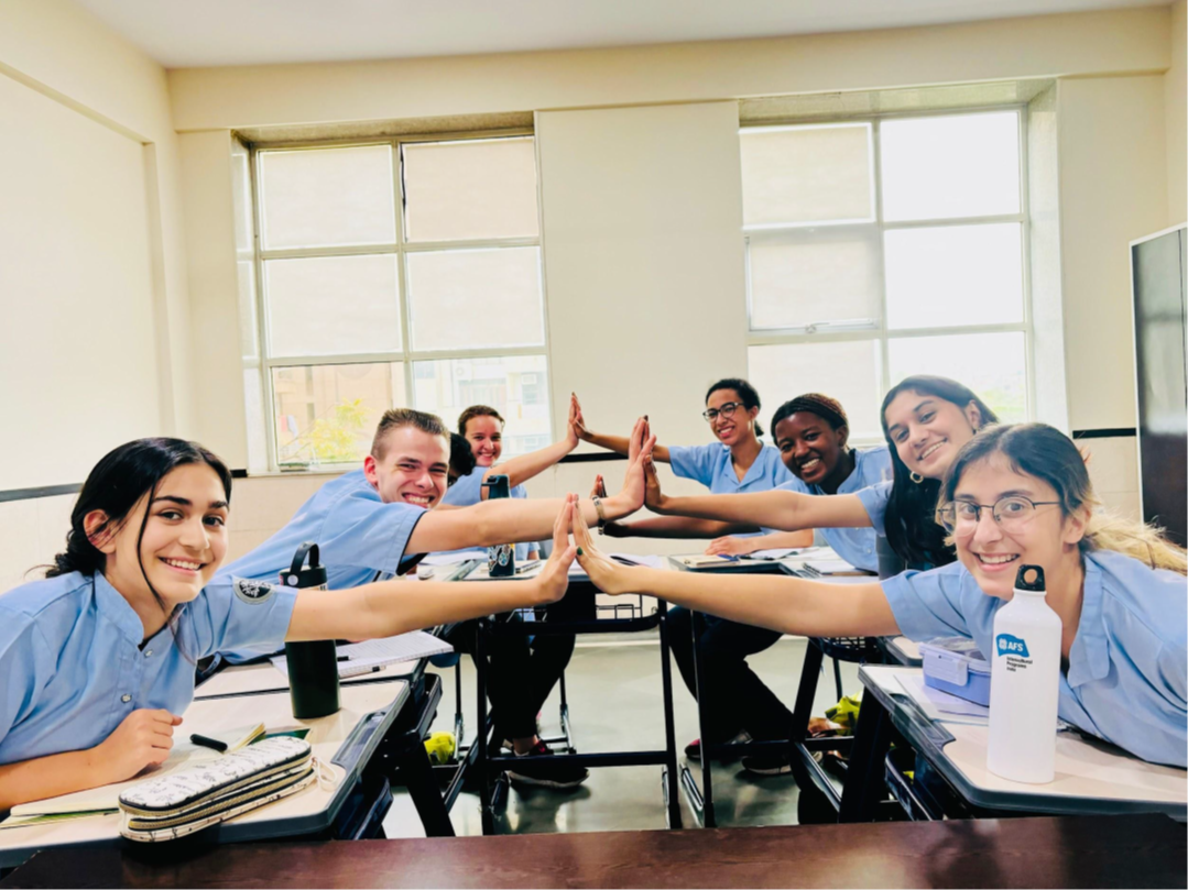 Students high-fiving one another in a language classroom
