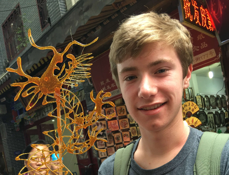 Andrew standing in front of a statue in China