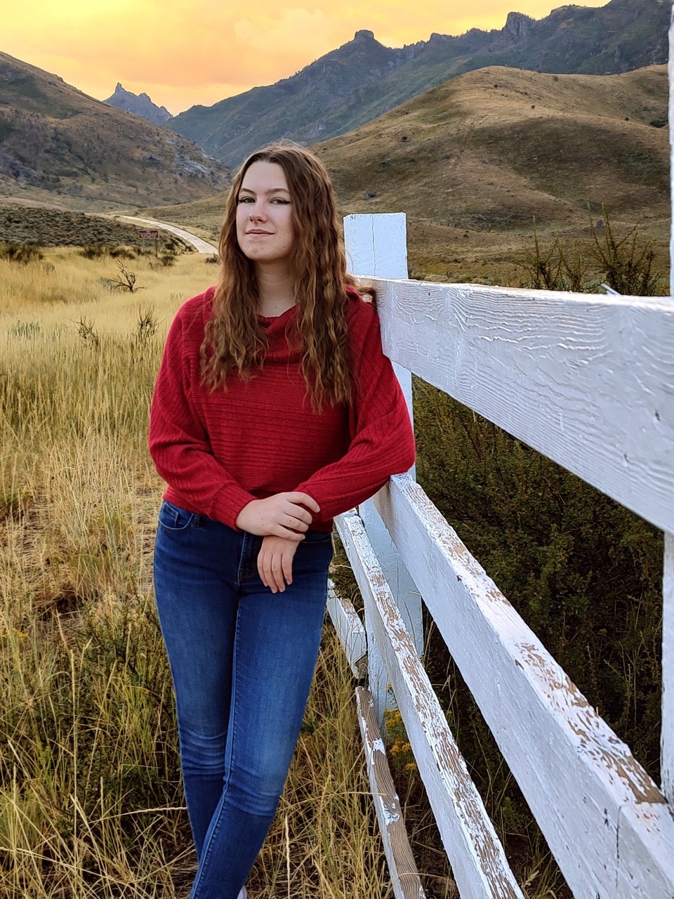Anna standing in front of a fence