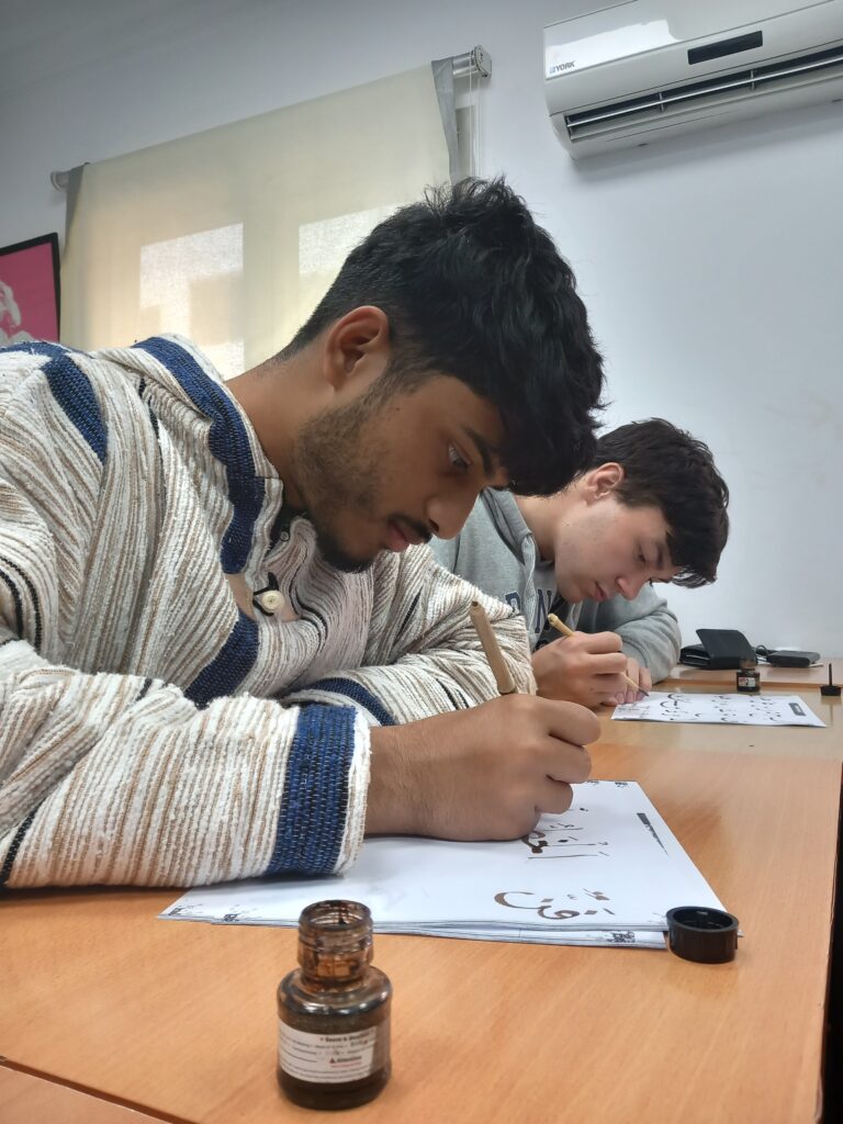 Student practicing calligraphy in Arabic class