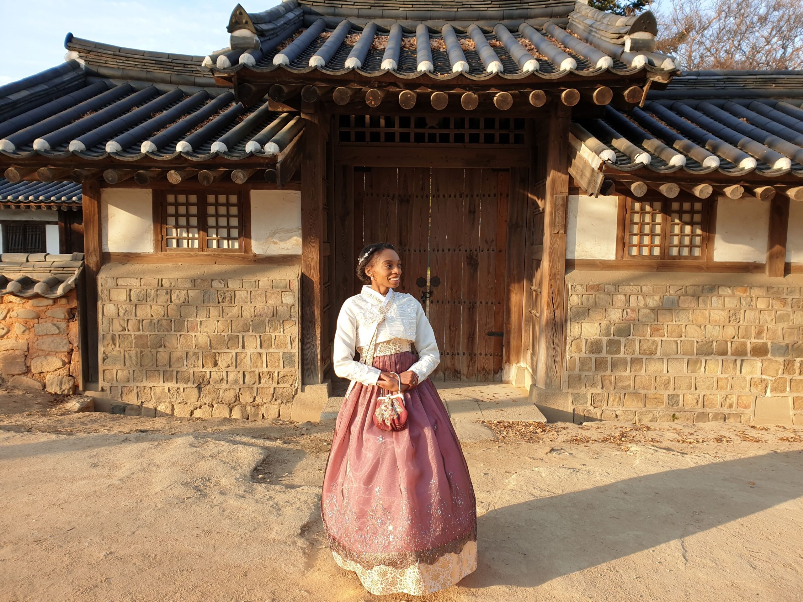 A NSLI-Y student poses in full traditional dress outside of a house in Korea