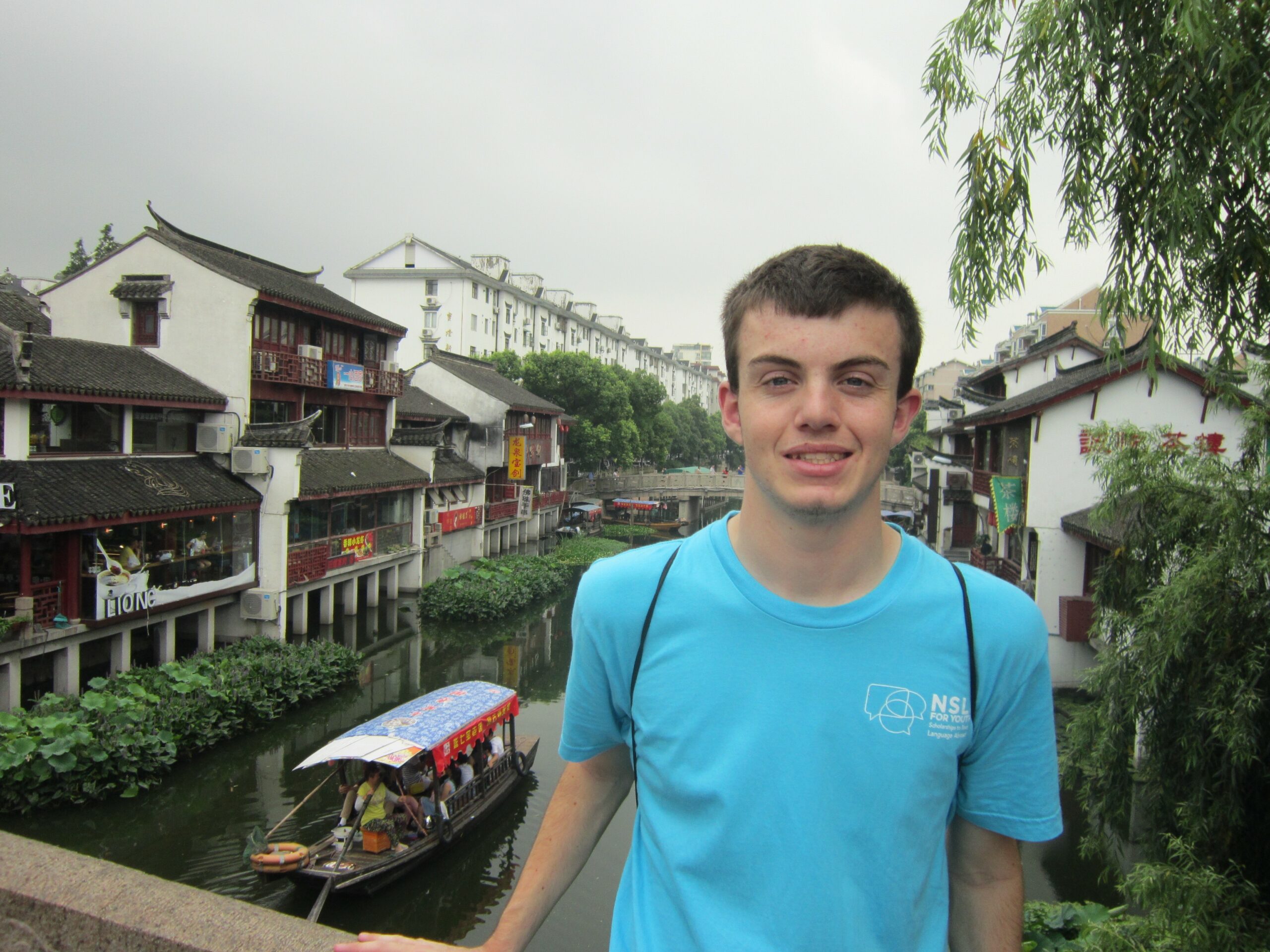 Daniel while on the NSLI-Y program standing on a bridge in front of a river.