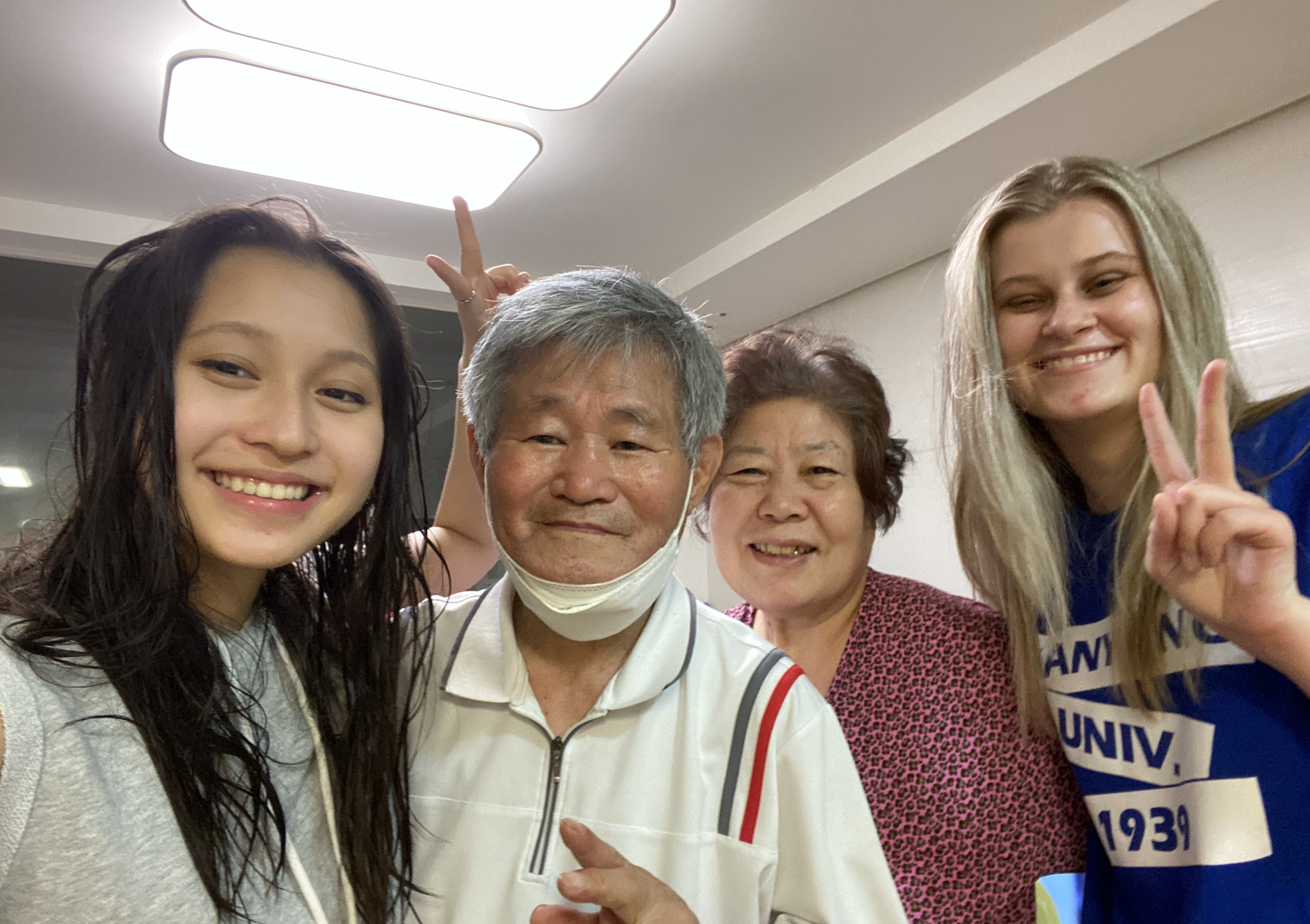 Emily poses with her host grandparents and fellow cohort member.