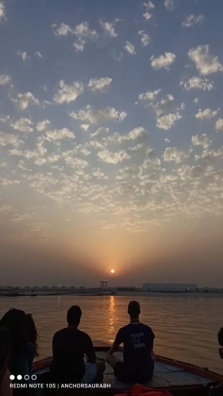 Students on a boat looking at the sunset