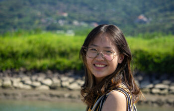 A Chinese language alumna smiles for the camera