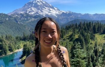 A Korean and Chinese language alumna poses in front of a mountain