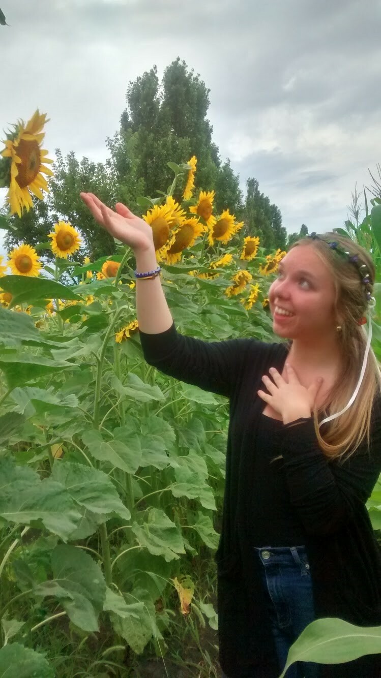 Isabella Baker poses in a field of sunflowers.