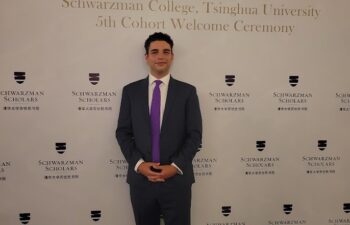 John standing in front of a sign as a Schwarzman scholar.