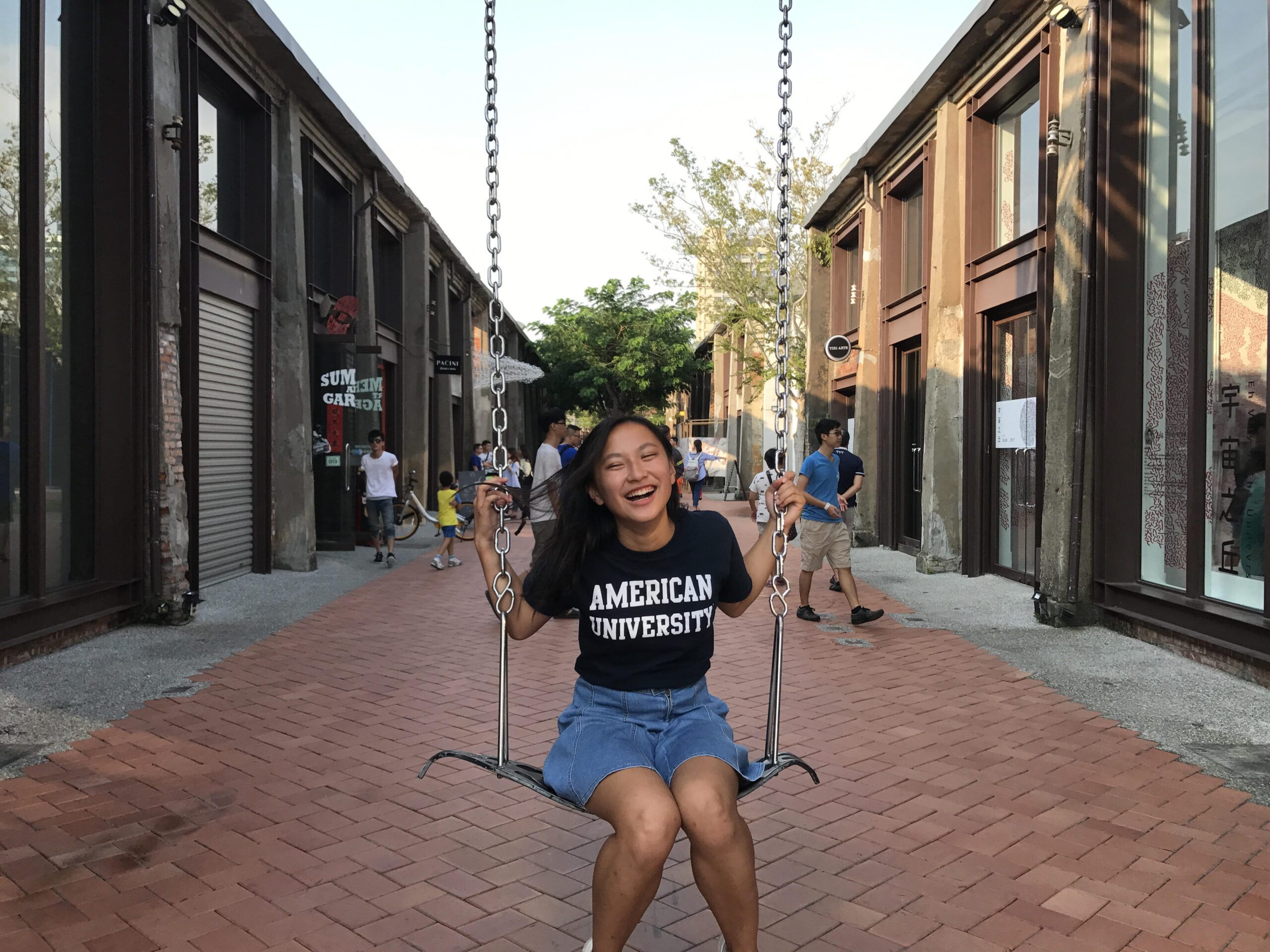 Image of Kate sitting on a swing and smiling