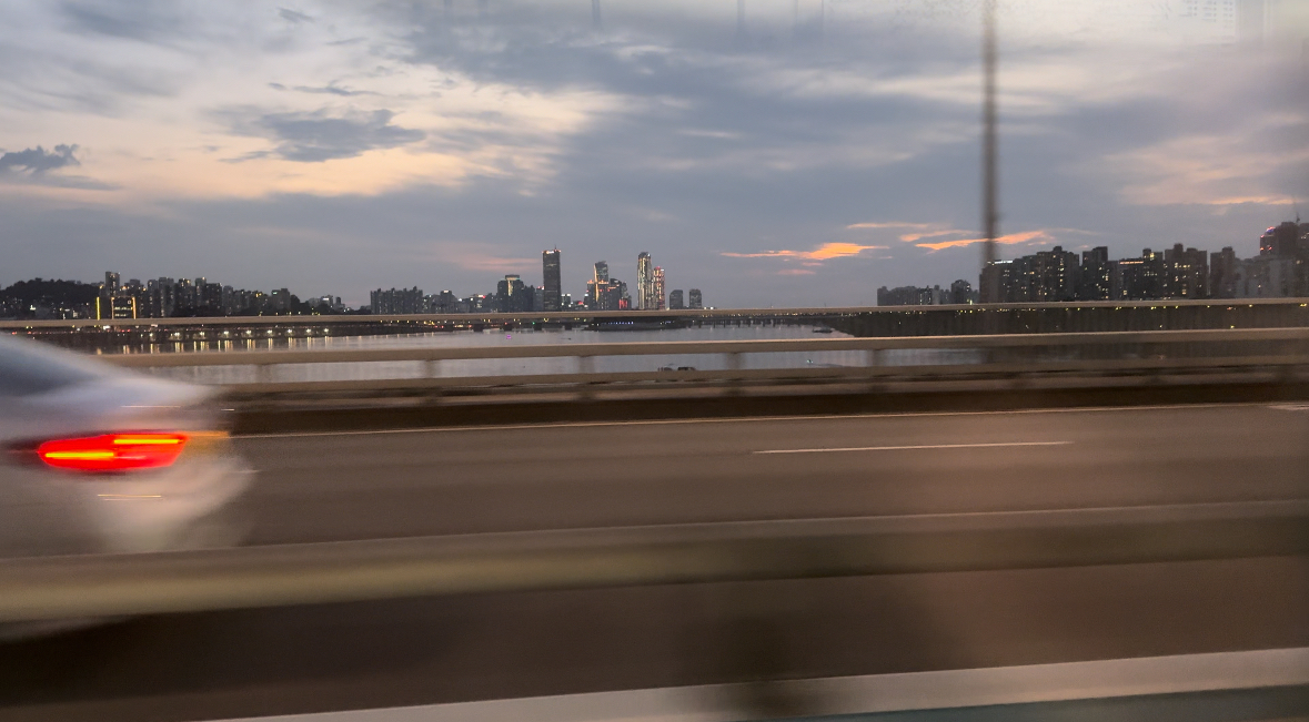 An image of the highway in Korea with city buildings in the background
