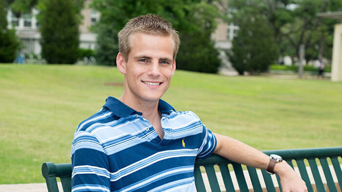 image of Matthew smiling and sitting on a bench