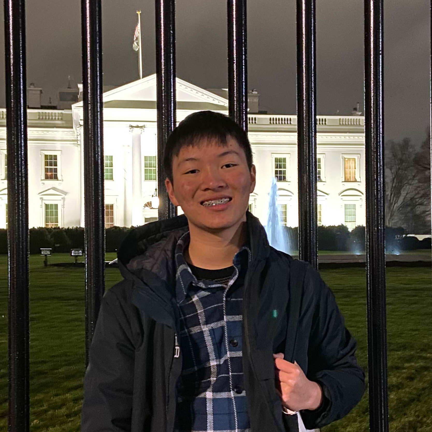 A student smiles in front of the White House