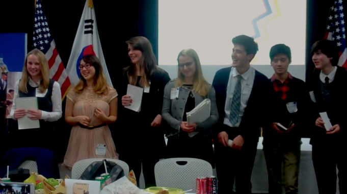 image of seven nsli-y students in formal wear standing in front of american and south korean flags