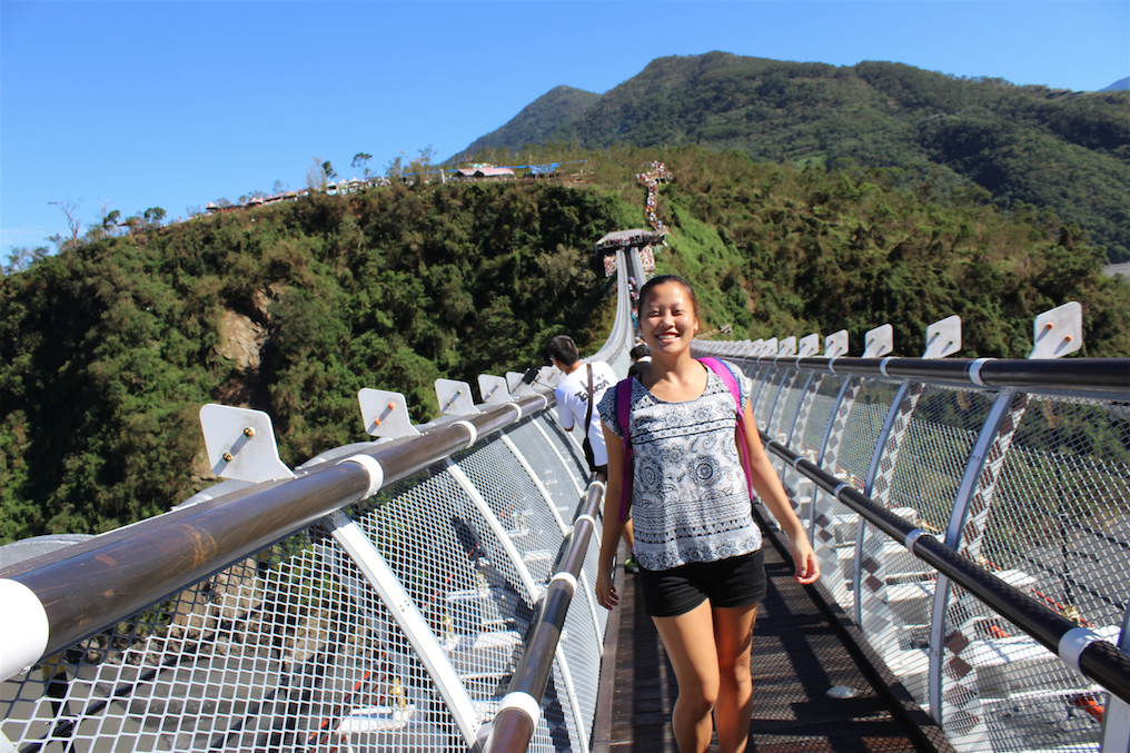 image of Mackenzie on a bridge in Taiwan in front of a mountainous landscape