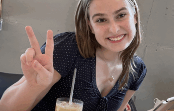 Maija smiles and displays peace sign.