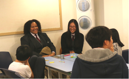 Image of Tiarra in a suit at a table