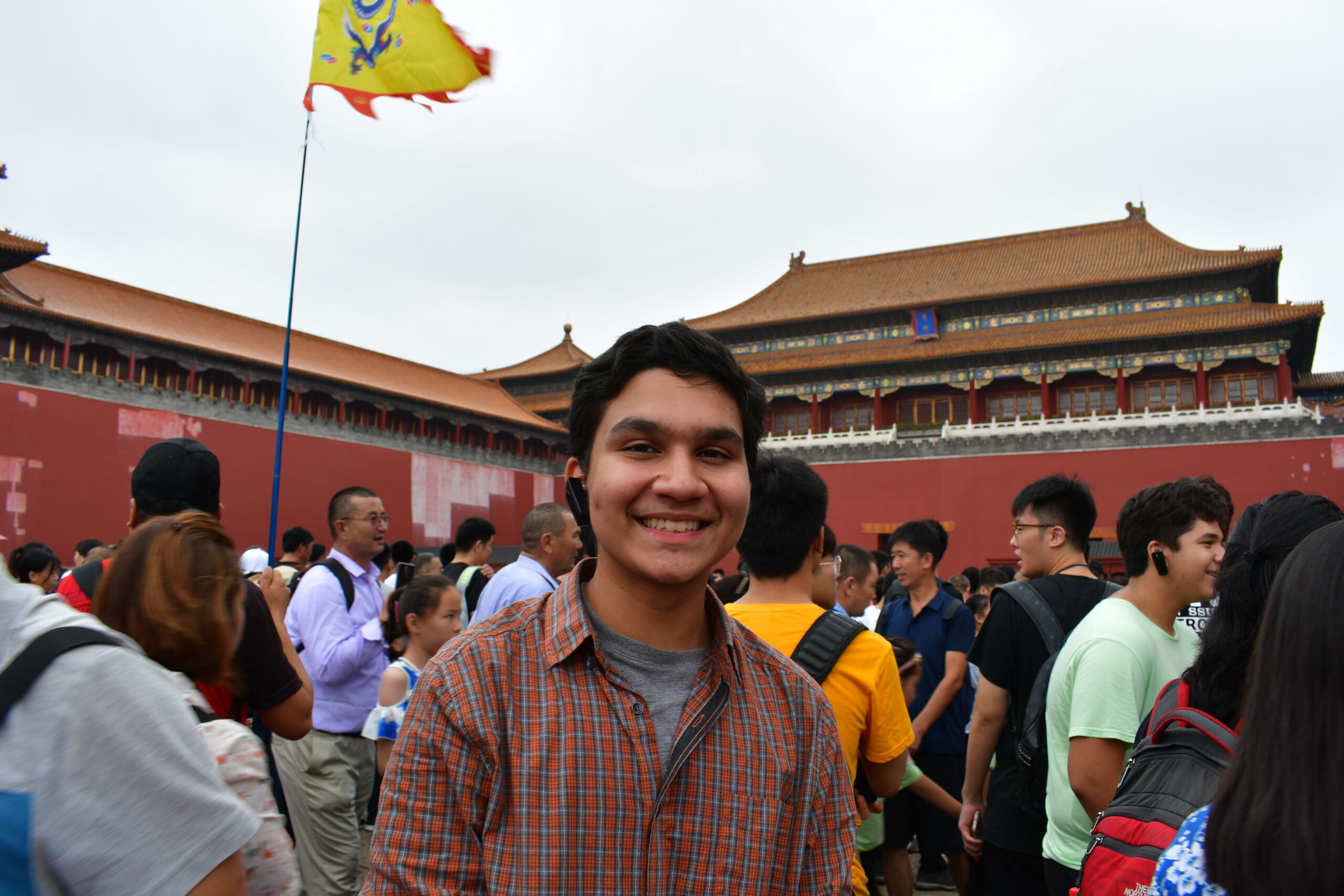 Shivam poses in front of a crowd of people in China
