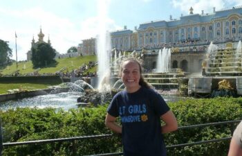 Kristen stands in front of a fountain.