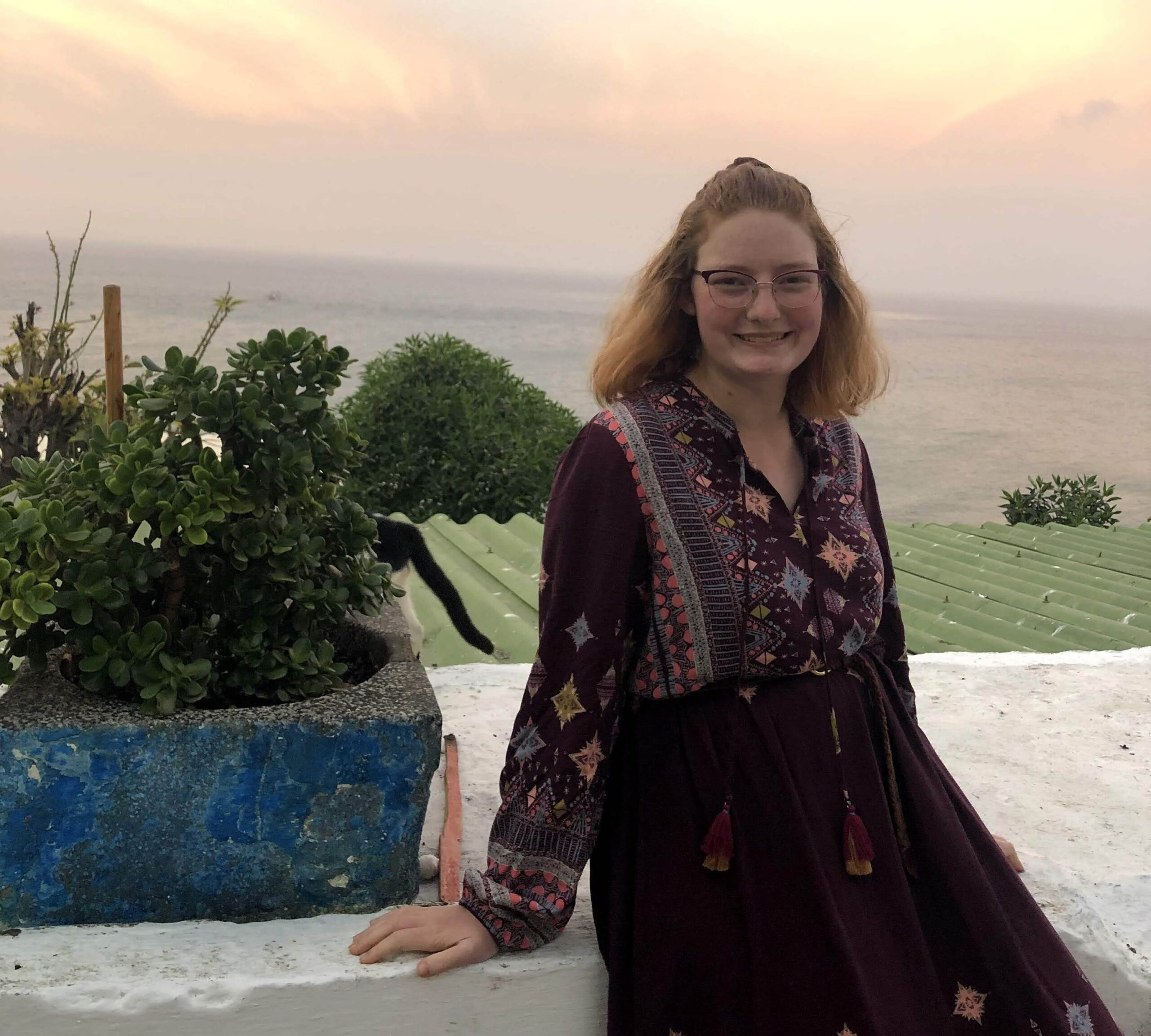 Emma poses in front of a sunset in Morocco