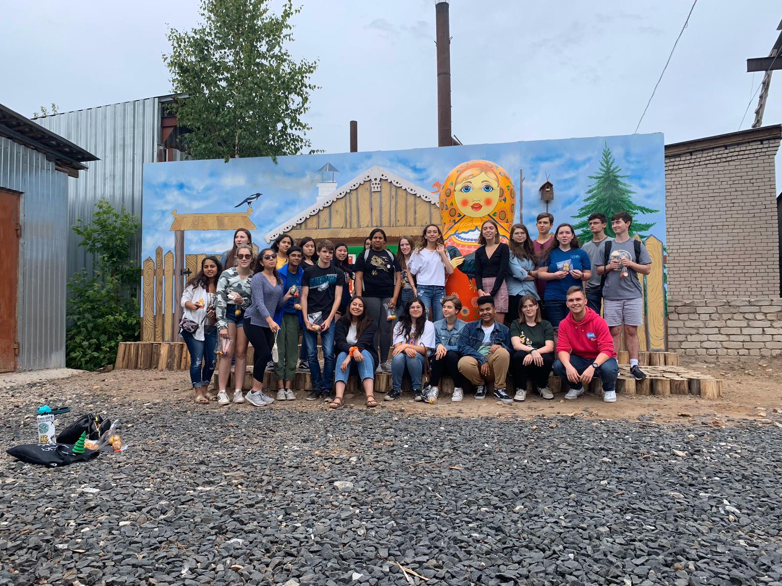 nsli-y cohort poses in front of a mural at the matryoshka factory