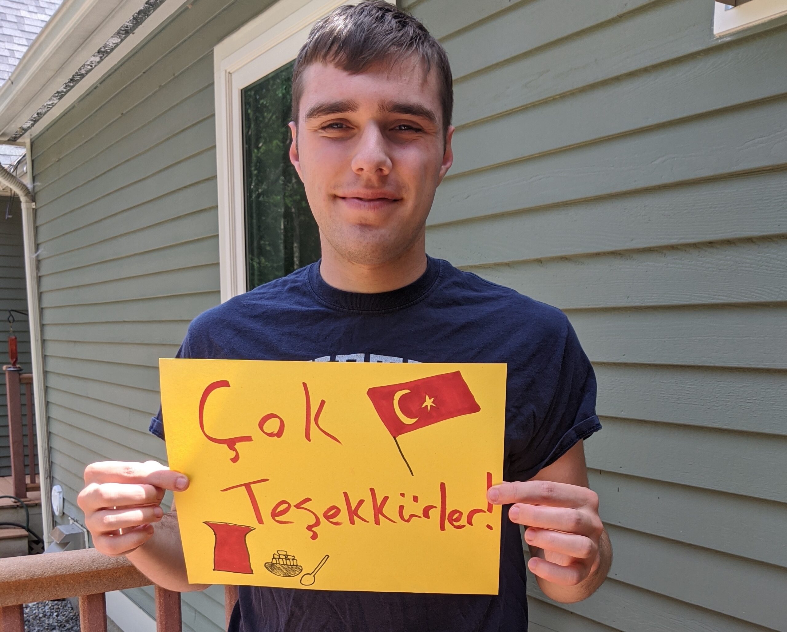 An image of Sawyer holding a sign that reads