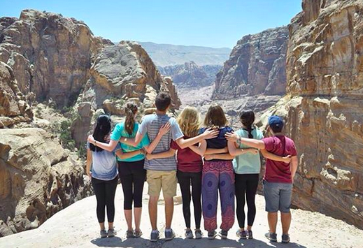 NSLI-Y Jordan Cohort poses together in front of a mountainous view