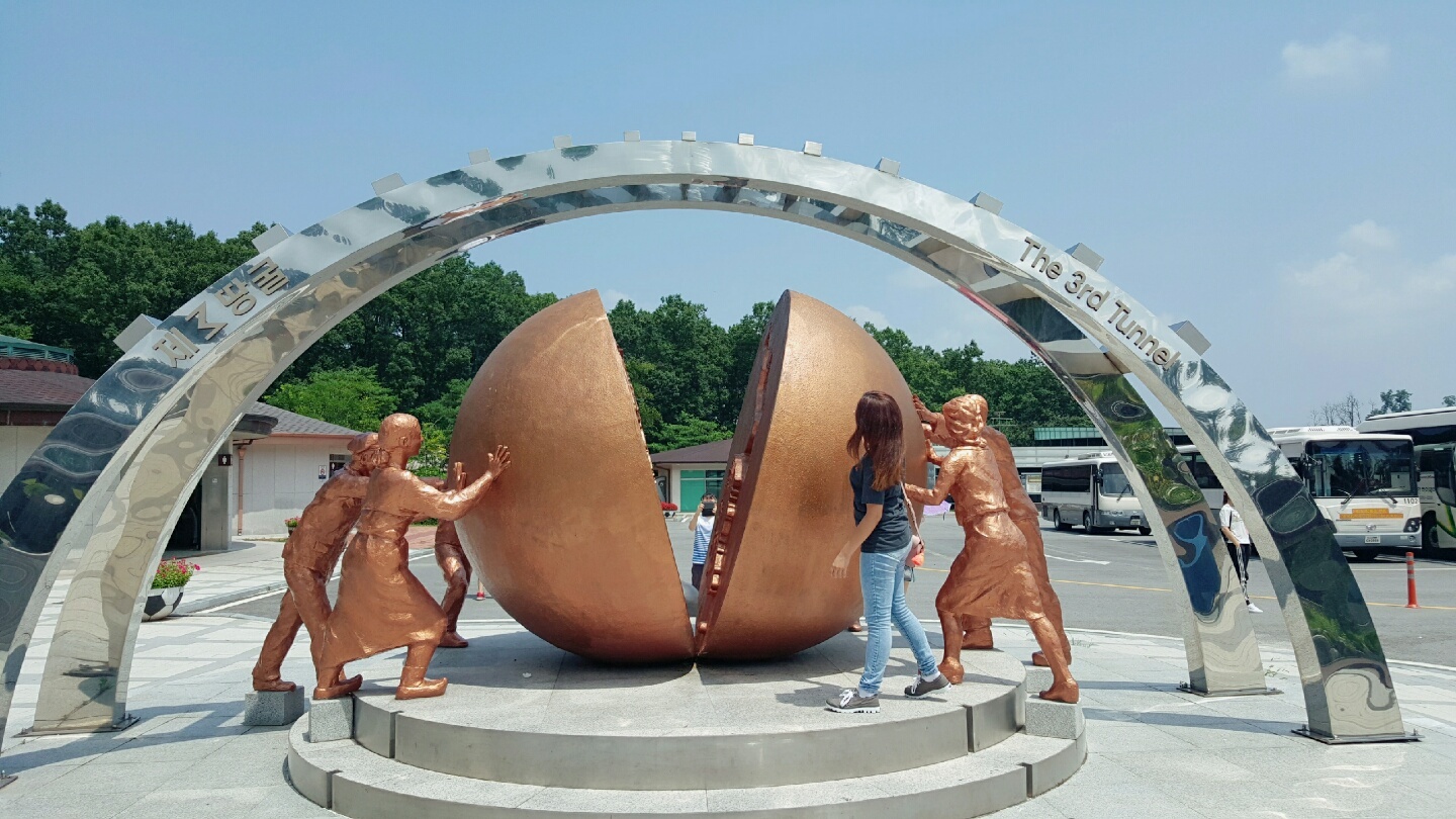 image of nsli-y student posing by a statue of golden figures holding up a split circle