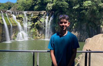 Daniel stands in front of the Shifen Waterfall in Taiwan.