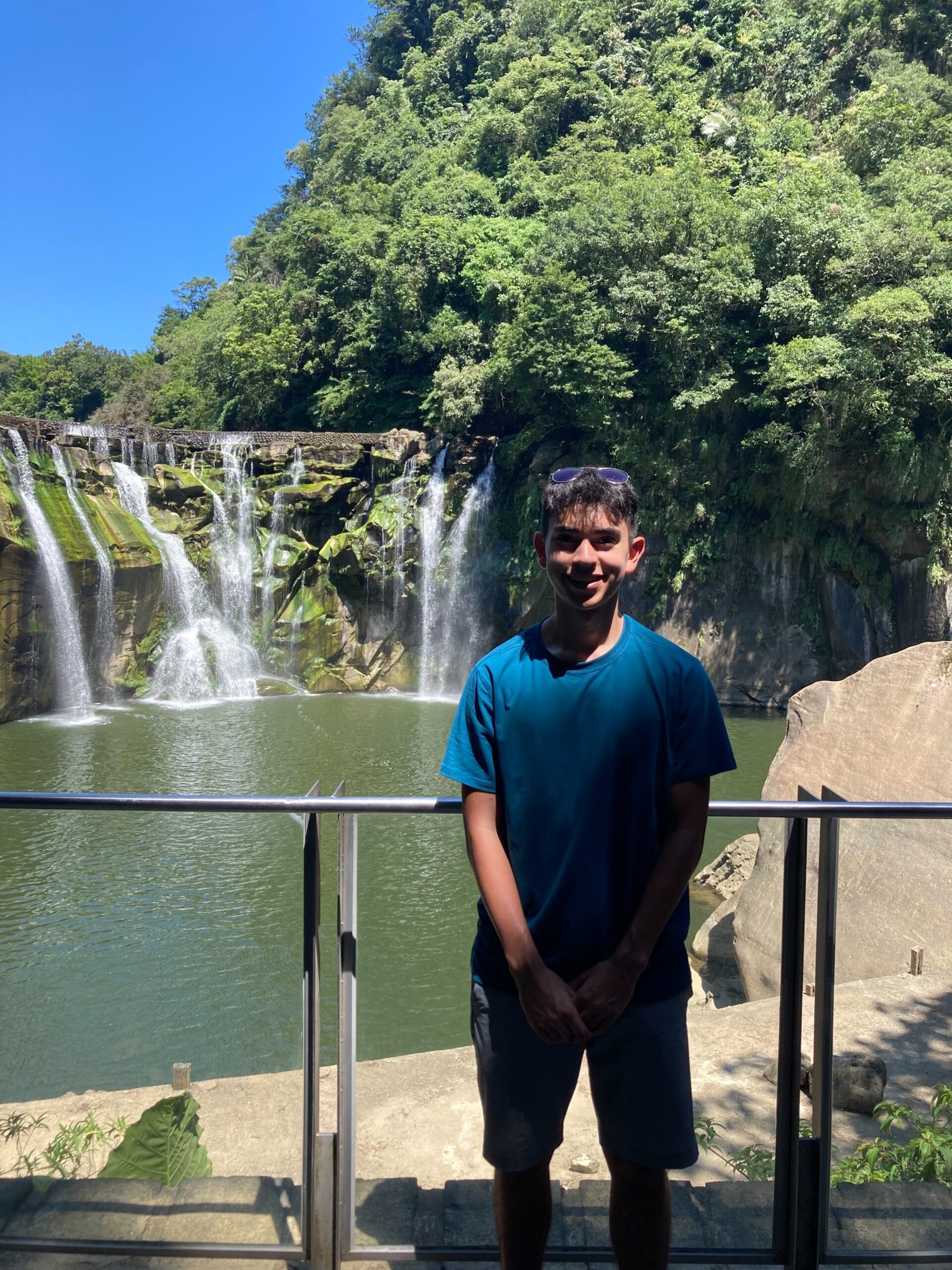 Daniel stands in front of the Shifen Waterfall in Taiwan.