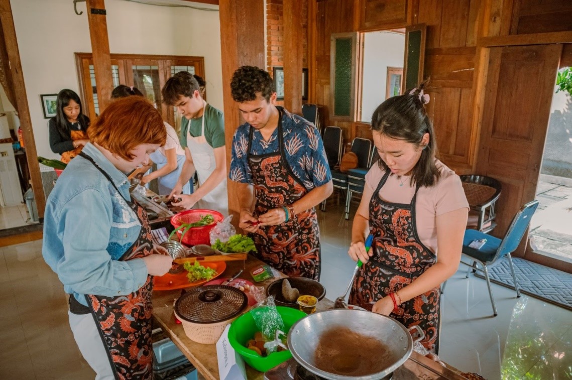 Participants wear aprons and prepare local foods in Indonesia