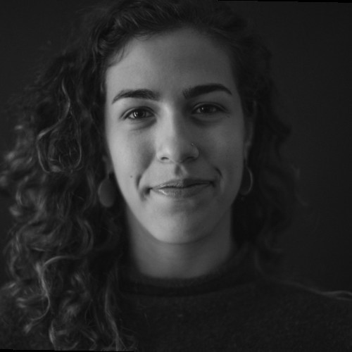 A headshot of a young woman in front of a dark background.